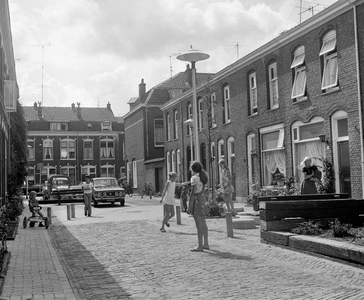 857240 Gezicht in de als leefstraat met plantenbakken en bankjes ingerichte Graanstraat te Utrecht, met enkele spelende ...